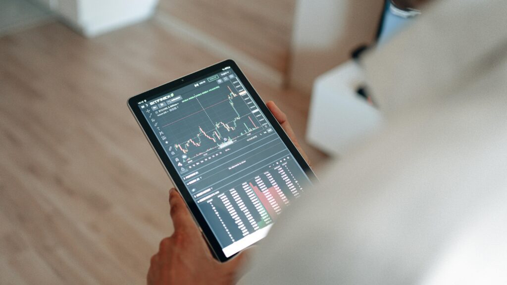 Pessoa segurando tablet com gráficos de análise de dados, simbolizando o mercado de software e a transformação digital.