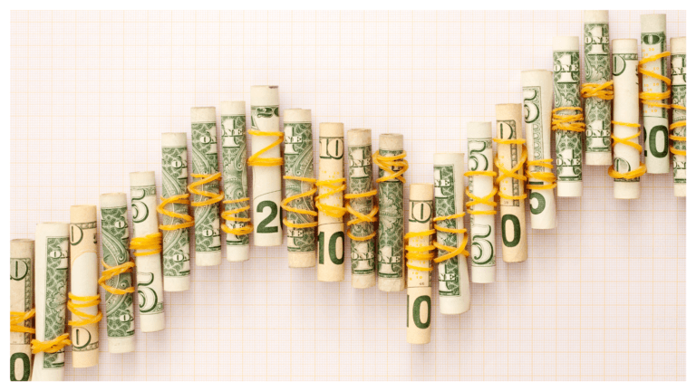 Rolos de notas de dólar organizados em um gráfico ascendente, simbolizando o impacto da variação do dólar nos custos de nuvem e infraestrutura de TI.