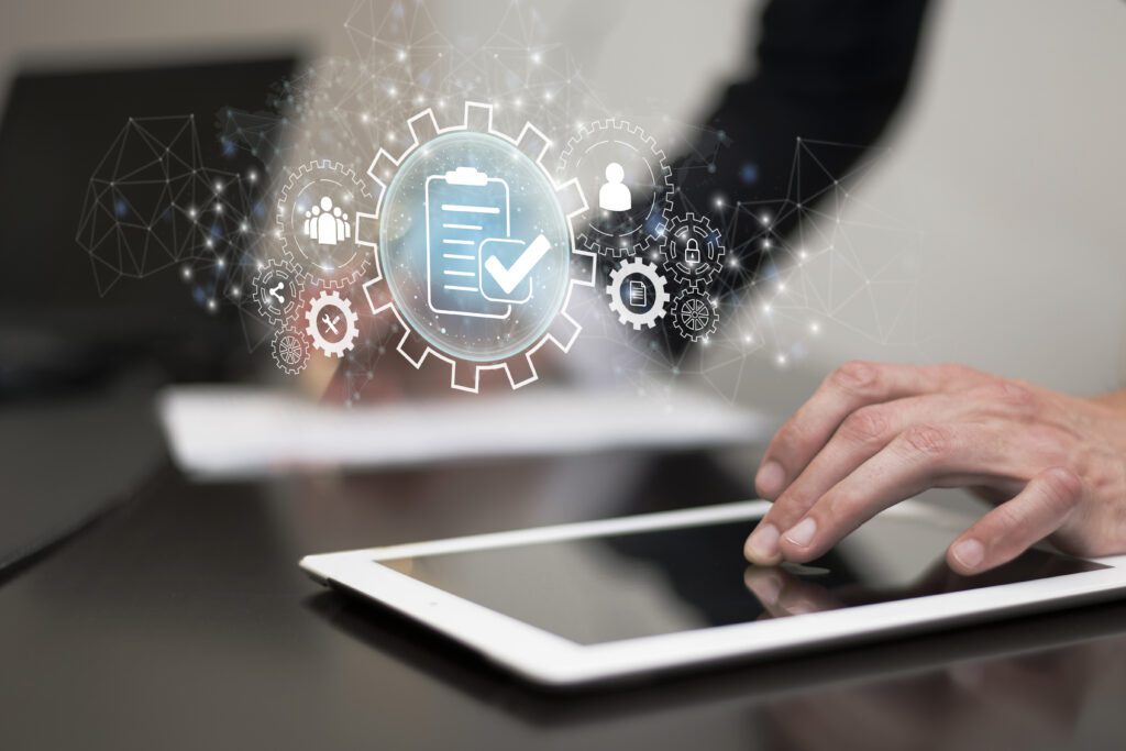 Mão utilizando um tablet com ícones digitais representando eficiência, personalização e automação em soluções personalizadas empresariais tecnológicas.
