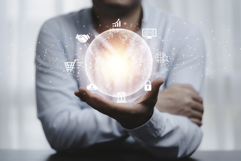 Mão de um profissional segurando uma representação digital do mundo, com ícones de tecnologia, segurança digital, e-commerce e inovação, simbolizando a transformação digital no ambiente corporativo.